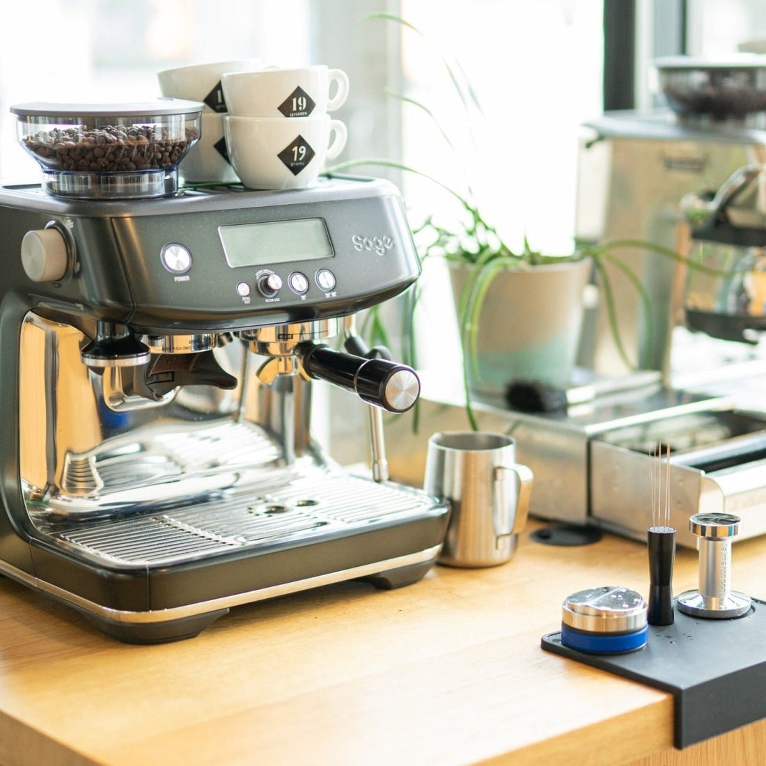 Sage Siebträgermaschine mit 19grams Kaffeetassen und Barista-Equipment beim 19grams Home Barista Workshop