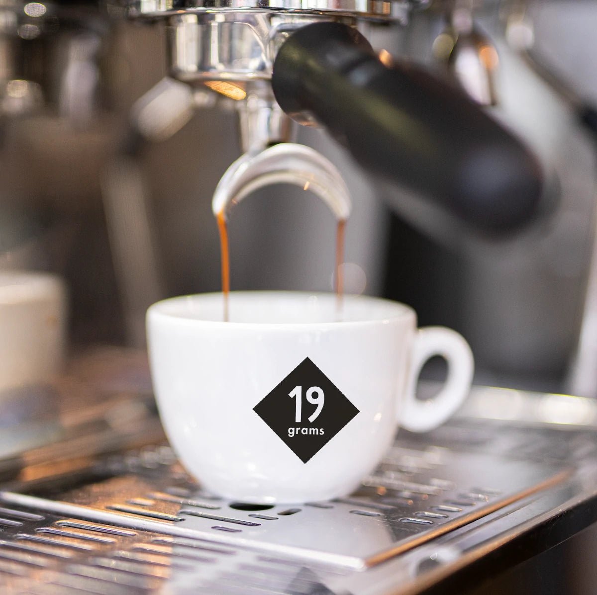 Espresso fließt in eine 19grams Markentasse aus dem Siebträger – Frisch gezogener Espresso bei 19grims.com Roasters Berlin