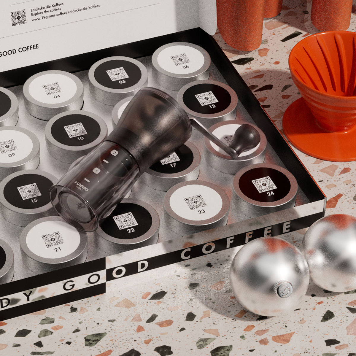 19grams Adventskalender 2026 – Geöffnete Kalenderbox mit nummerierten Aluminiumdosen und einer Hario-Handmühle, daneben ein oranger Handfilter
