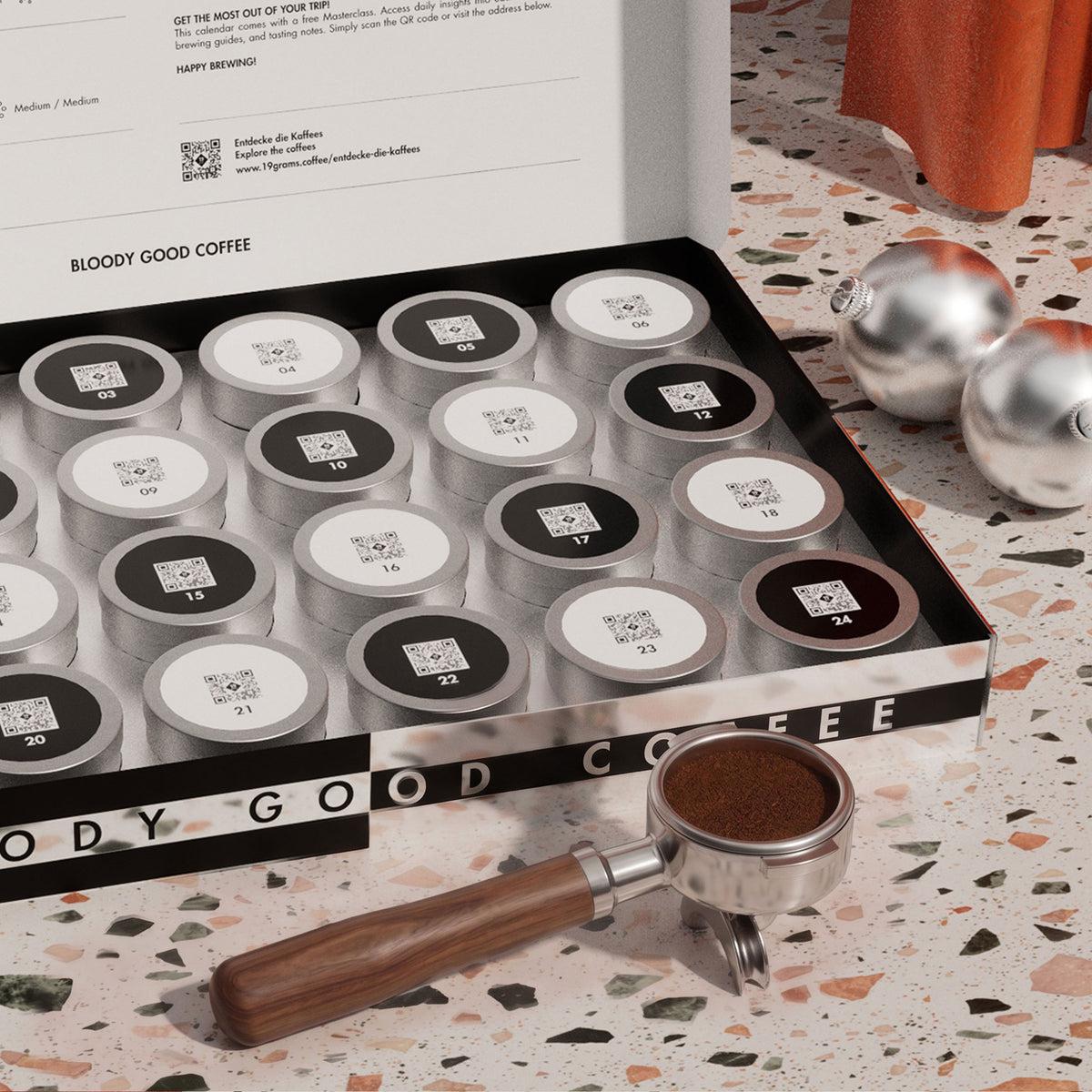 19grams Kaffee Adventskalender 2026 – 24 Türchen – Mood-Foto des geöffneten Kalenders mit nummerierten Dosen und gefülltem Siebträger auf Terrazzo