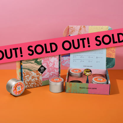 19grams The Fermentation Project Kaffee Kit Espresso – Produktmockup der marmorierten Geschenkbox mit geöffneter Versandbox, silbernen Kaffeedosen und goldenem Löffel vor rosa-orangem Hintergrund, mit Sold-Out-Banner