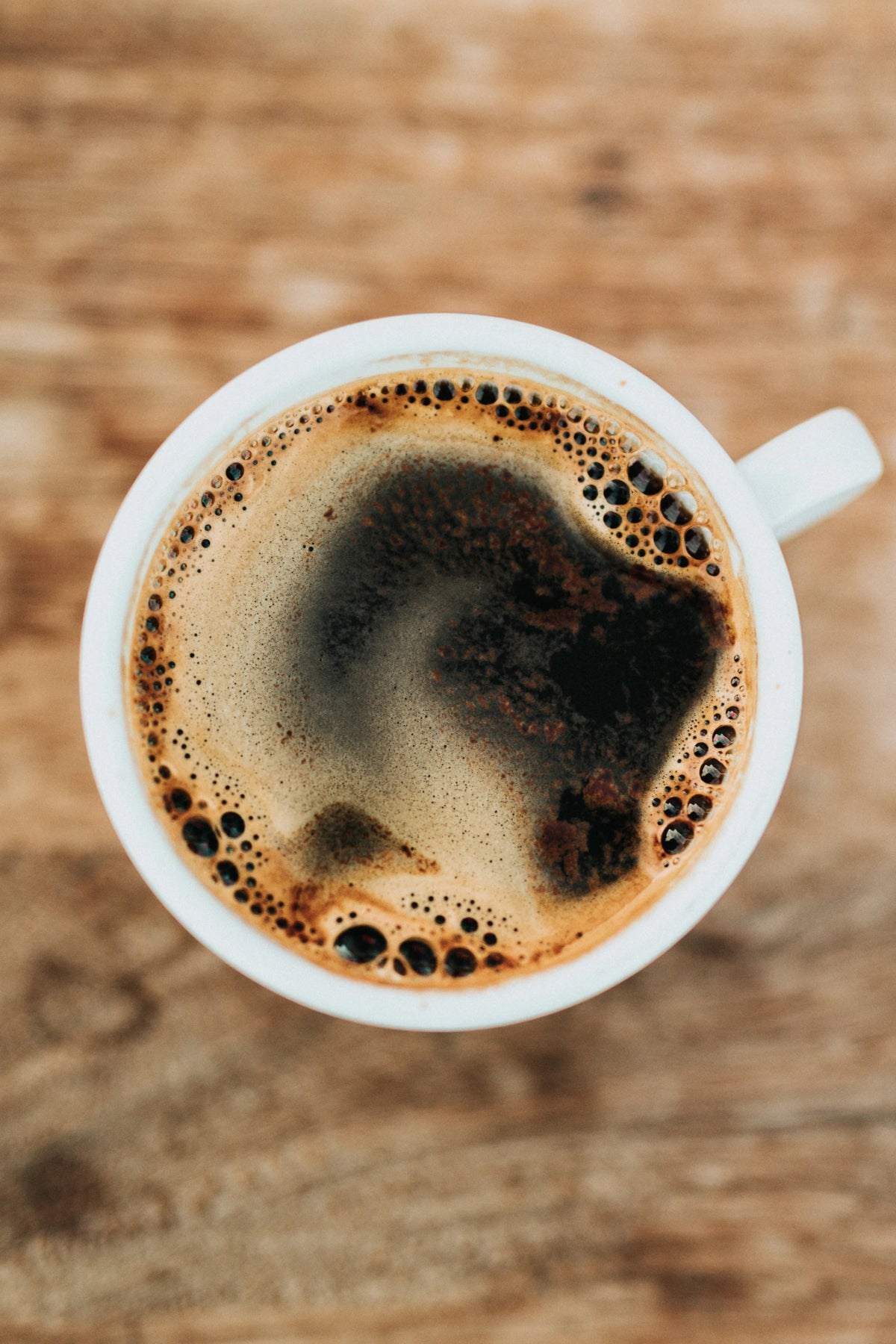 Schwarzer Kaffee in weißer Tasse von oben auf Holzuntergrund – Specialty Coffee Flat-Lay bei 19grims.com Roasters Berlin